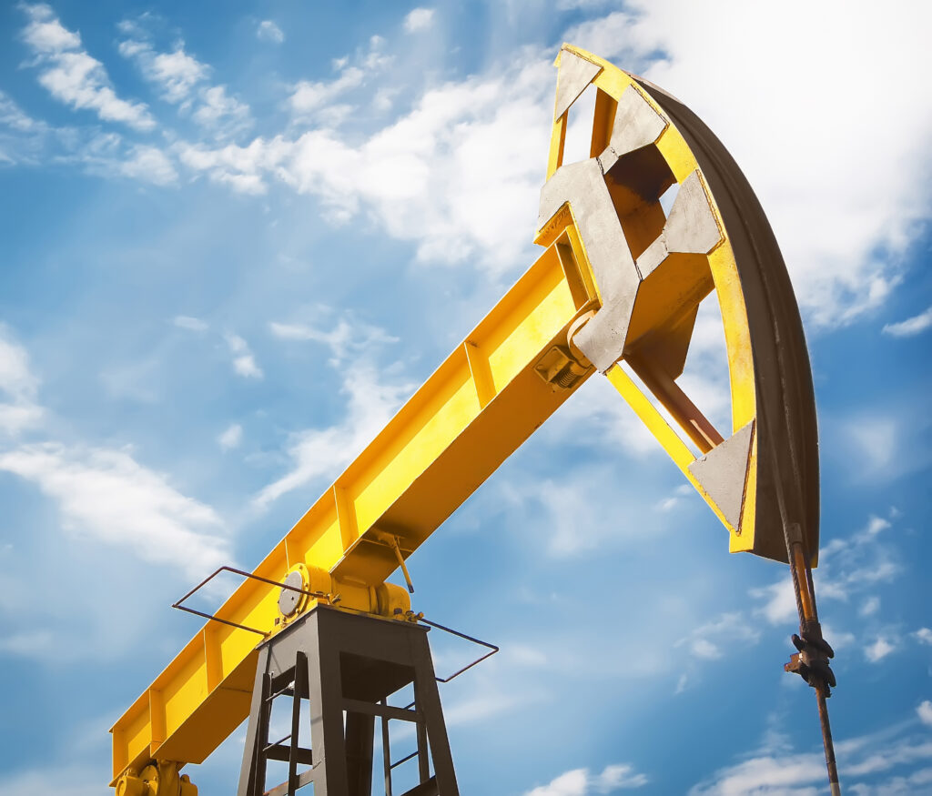 The head of a yellow oil well pumpjack