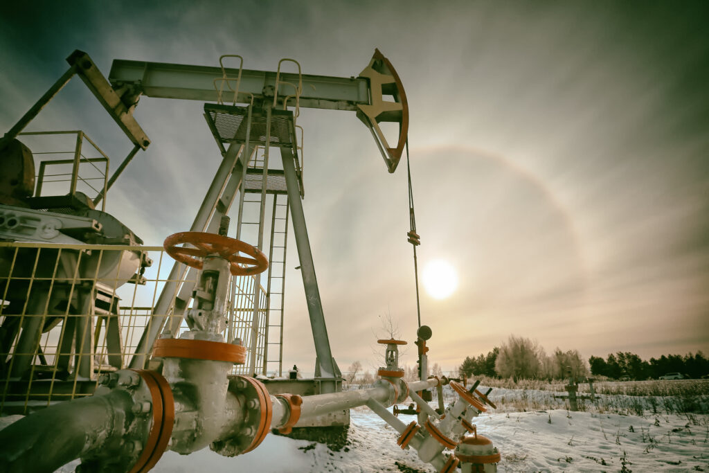 An oil well pumpjack in a snowy field