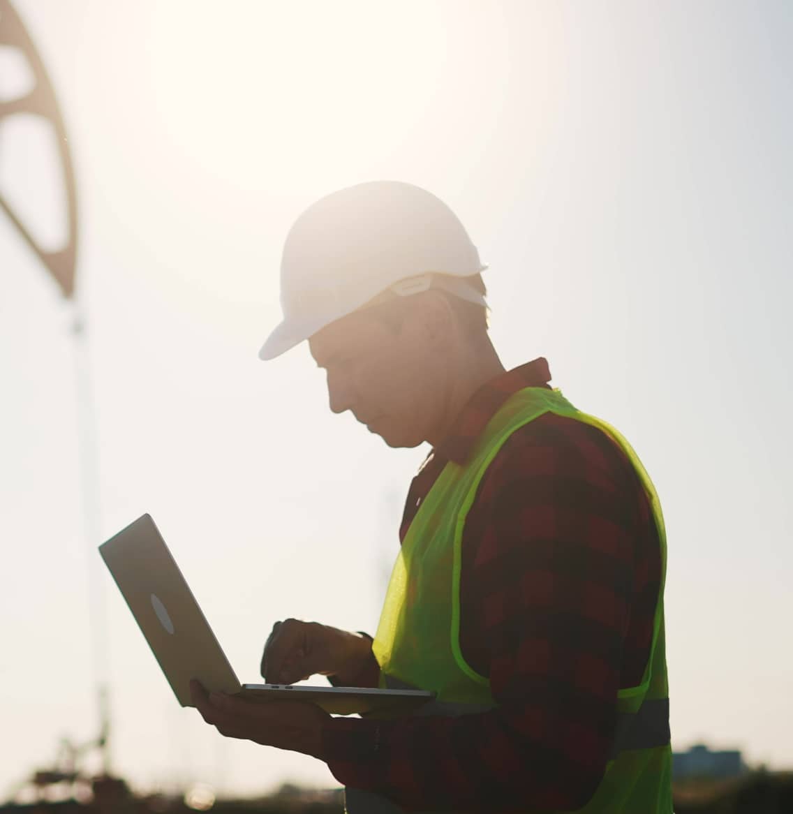 Petroleum engineer on a laptop at a well site